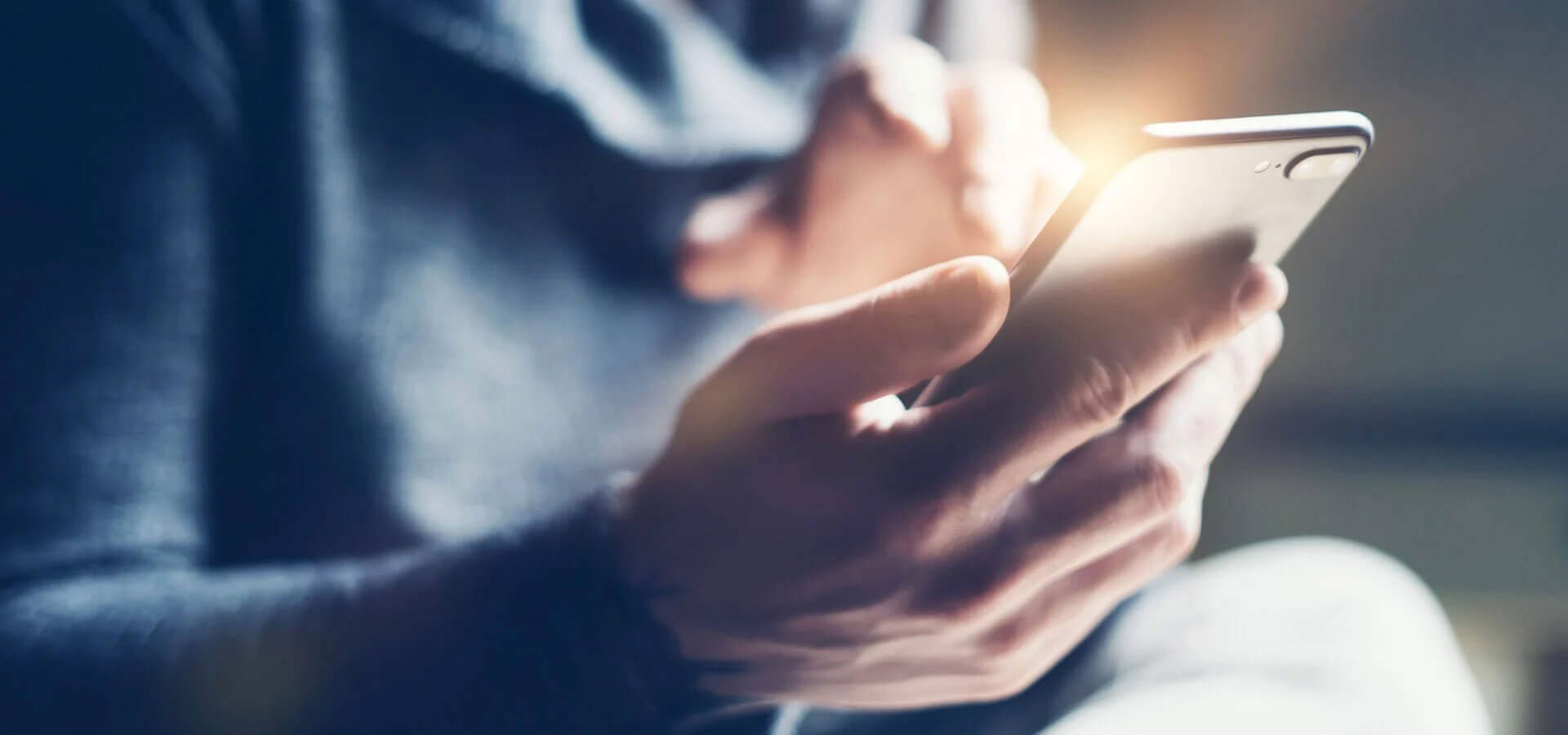 A person using a smartphone with a blurred background.